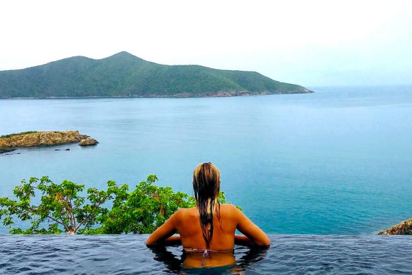 Woman In Infinity Pool Overlooking Island